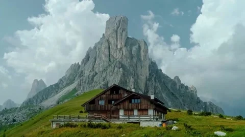 Aerial: A simple, small and comfortable house under a towering cliff Stock Footage 145355763