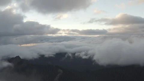 Aerial sits above the clouds and High Rock Lookout in Washington at dusk Stock Footage 345171351