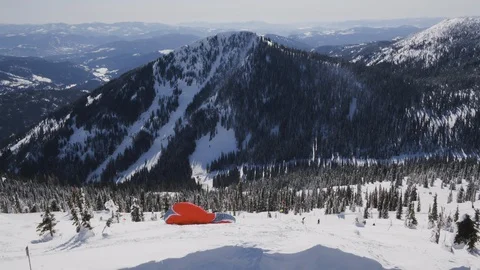 Aerial of skier using parachute to glide over snowy hill on sunny day, Canada Видео 121586842