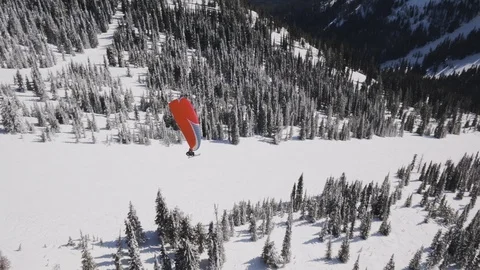 Aerial of skier using parachuting above snowy hills with forest, Red Mountain Video stock 121586957