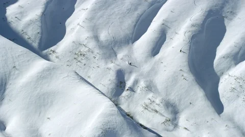 Aerial of skiers freeride skiing down on snowy hill in Alaska Stock Footage 129117964
