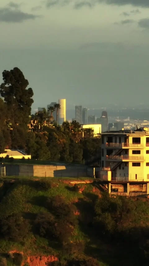 Aerial slide and pan shot of luxury residences in Hollywood Hills. Revealing cit Vídeo Stock 337414031