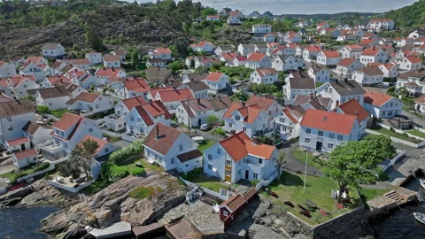 Aerial slide over dense cluster of white houses with red roofs in Risor Norway. Stock Footage 328125033