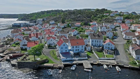 Aerial slide over dense cluster of white houses with red roofs in Risor Norway. Stock Footage 328125050