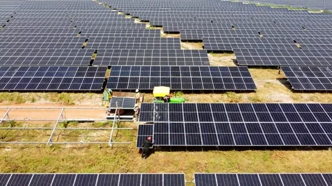 Aerial sliding view of workers offloading and installing solar panels at 動画素材 296783351