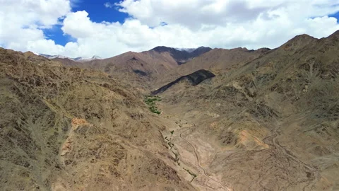 Aerial slow arc shot of a deep desert canyon and rugged mountain ridges Stock Footage 339157410