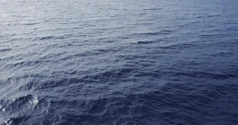 Aerial slow motion close up of disturbed blue ocean water surface Stock Footage 325561743