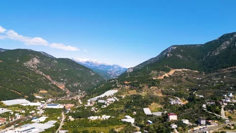 Aerial Slow Motion Drone Flight Over Green Mountains with Snow-Capped Peak Stock Footage 309203567