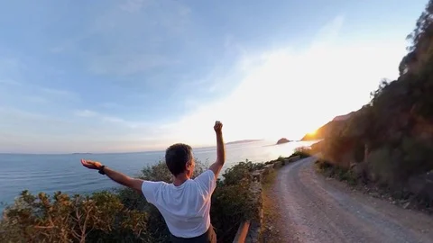 Aerial Slow Motion, a man standing near a scenic path on the cliff  at sunset Stock Footage 107920982