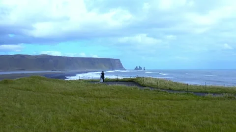 Aerial slow motion panoramic view of two newlyweds stand on the edge of a cliff Stock Footage 167079438