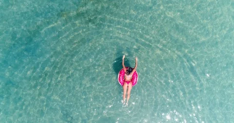 AERIAL. Slow motion top view of young pretty sexy girl swimming with pink Stock Footage 86658675