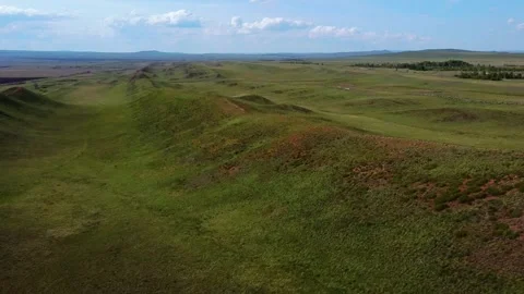 Aerial slow motion tracking view of rolling grass hills and ridgeline stret.. Stock Footage 335801769