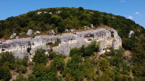 Aerial slow motion tracking view of limestone cliff and trees rising on for.. Stock Footage 335801794