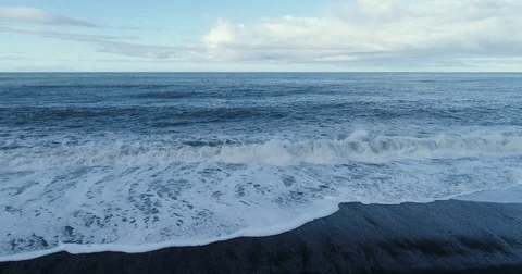 Aerial slow motion view of ocean waves crashing on beach Video stock 79857693