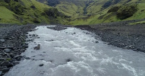 Aerial slow motion view of rushing rivers in green valley Видео 79857862