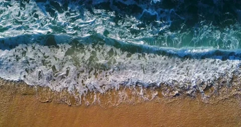 Aerial slow motion view of the waves breaking at the beach Stock Footage 130910623