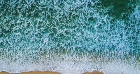 Aerial slow motion view of the waves breaking at the beach Stock Footage 130946617