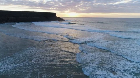 Aerial Slow Motion Of Waves Breaking On Shore During Sunset Video stock 79646840