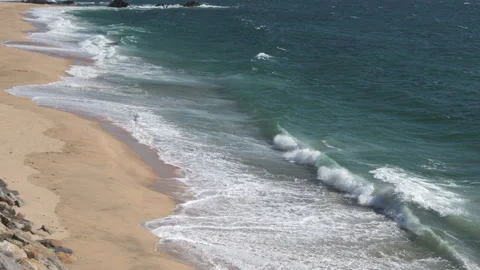 Aerial slow motion waves breaking on sandy beach in summer 動画素材 132228358