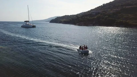 Aerial, small boat with same people, sailing between the sun reflexes of the sea Stock Footage 96297726