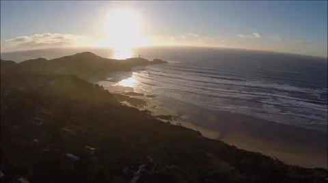 Aerial small cove beach waves and lighthouse approaching sunset.mp4 Video stock 46380663