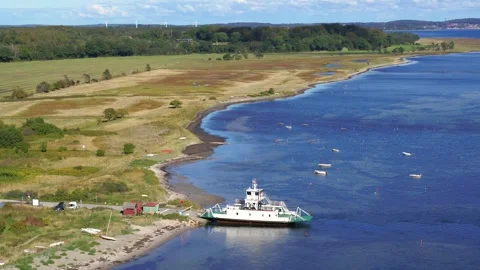 Aerial of small local ferry docking at a small pier in Denmark Stock Footage 305563605