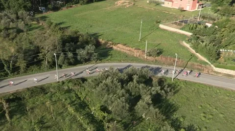 Aerial Small pack of cyclists along a curvy road Stock Footage 22204052