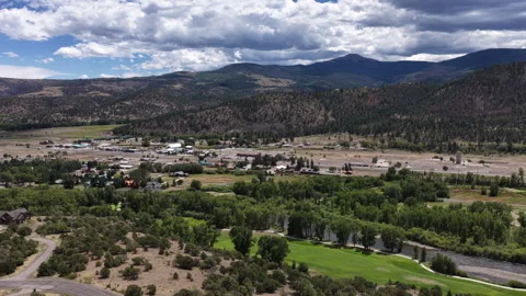 Aerial of small town South Fork Colorado with golf course mountains and forest Stock Footage 342748680