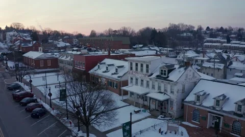 Aerial of small town in winter snow, decorated for Christmas holidays. Stock Footage