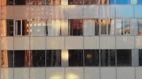 AERIAL. Smooth camera movement in front of office building windows reflecting Stock Footage 131405122