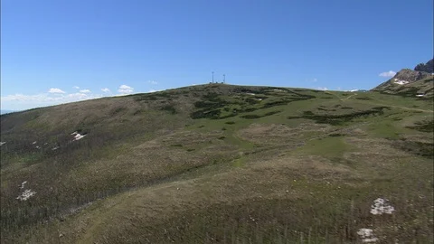 Aerial of snow capped mountain range and green grass fields, East Side Stock Footage 109456300