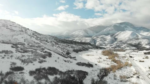 Aerial-Snowy valley distant cloudy mountain-Pan Stock Footage 99522401