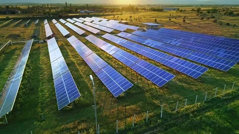 Aerial solar power plant green grass field alternative energy panels sunlight Stock Footage