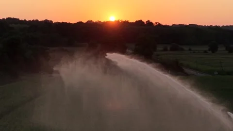 Aerial of a Sprinkler machine in front of the sunset, Corn monoculture in a hot Stock Footage 326813963