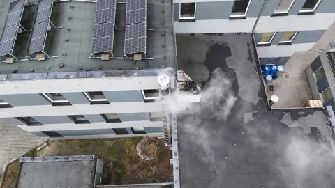 Aerial Static Pan Left of Smoking Chimney on Building Roof Video stock 323965045