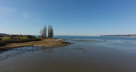 Aerial static to push along shore sunny day Stock Footage 86956582