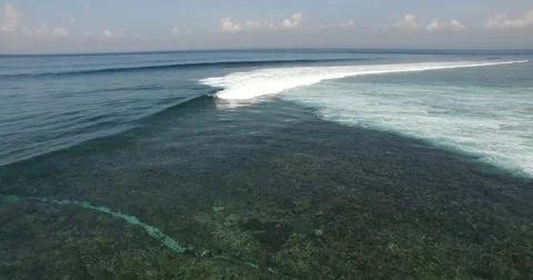 AERIAL static shot of waves breaking over coral reef in Indonesia Stock Footage 59882381