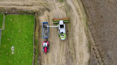 Aerial Static View of Combine Harvester Unloading Grain into Tractor Trailer Stock Footage 341846512