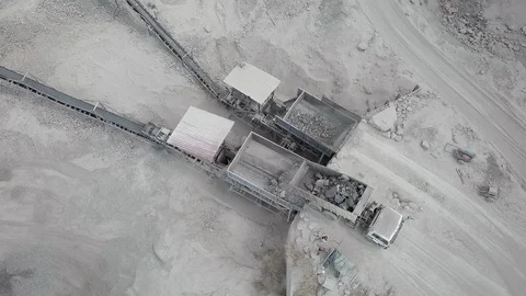 Aerial static view of dump truck unloading rocks into a crusher machine Stock Footage 127593533