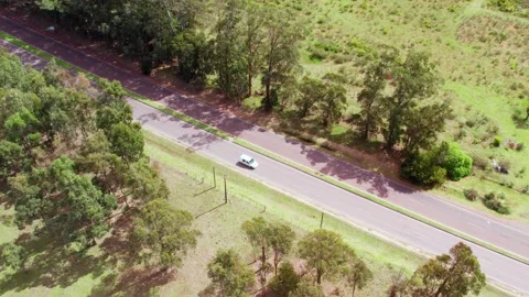 Aerial static view of a road grader widening side road in the countryside Stock Footage 220917726