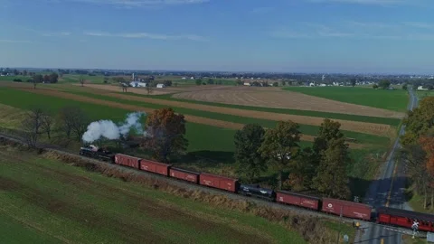 Aerial of a Steam Train With Red Freight Cars Moves Through Vast, Patchwork.. 스톡 동영상 282070134