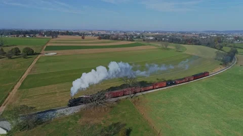Aerial of a Steam Train With Red Freight Cars Moves Through Vast, Patchwork.. Stock Footage 282890142