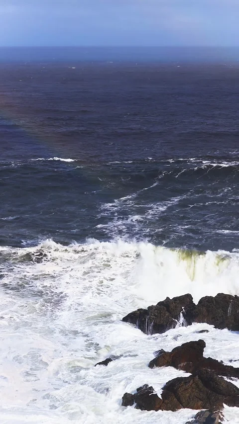 Aerial storm waves at Cape of Good Hope with rocks and rainbow Stock Footage 336287275