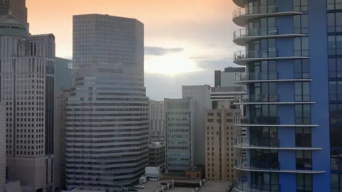 Aerial - Sun flares off Downtown Skyscraper Stock Footage