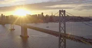 Aerial Of Sun Shining Through San Francisco Bay Bridge, Golden Hour Stock Footage