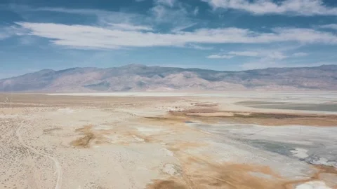Aerial sunny empty plain brown beige dry dirt California salt flat blue sky Stock Footage 145173448