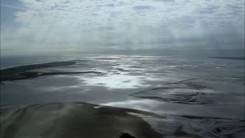 Aerial of sunrays falling on the wet sand near the sea coast at dusk, East Stock Footage 109118512