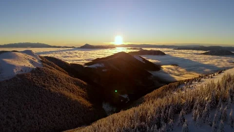 Aerial sunrise pullback over winter mountains above sea of clouds inversion in Stock-Footage 327594529
