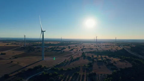 Aerial sunrise view of wind turbines across rural farmland Stock Footage 317641053