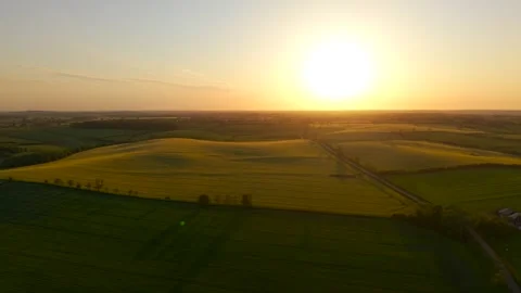 Aerial sunset landscape over patchwork farmland and green crop fields. Warm 動画素材 338068018